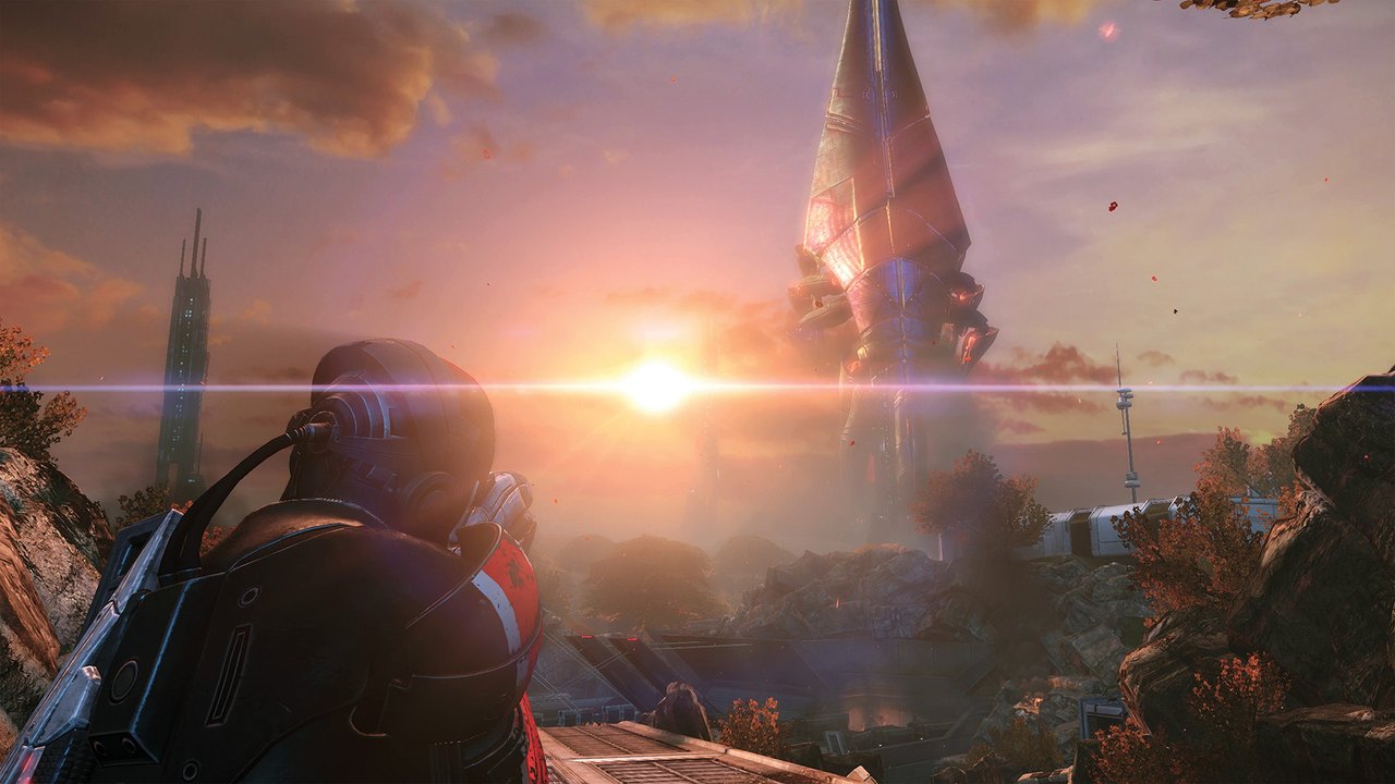 Commander Shepard looking out at a towering alien ship at sunset in Mass Effect Legendary Edition